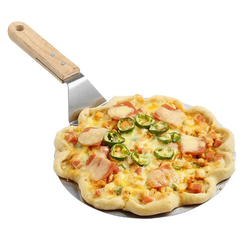 A round stainless steel pizza paddle with a wooden handle is shown next to a freshly made pizza.