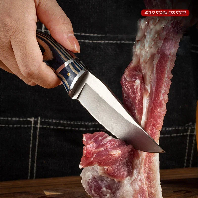 A hand holds a stainless steel survival knife with a wooden handle, positioned next to a piece of raw meat.