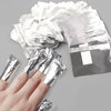 A hand is holding and displaying several sheets of silver aluminium foil nail removal wraps.