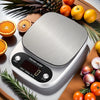 A silver digital kitchen scale is shown next to various fresh fruits and vegetables like oranges, tomatoes, and garlic.