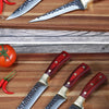 A set of three forged stainless steel kitchen knives with wooden handles and silver blades are displayed on a wooden surface.