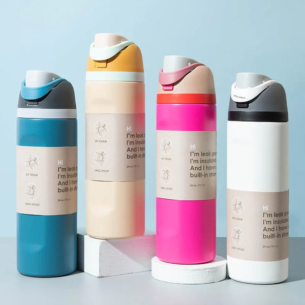Four insulated stainless steel sports tumblers in various colors lined up on a light surface.