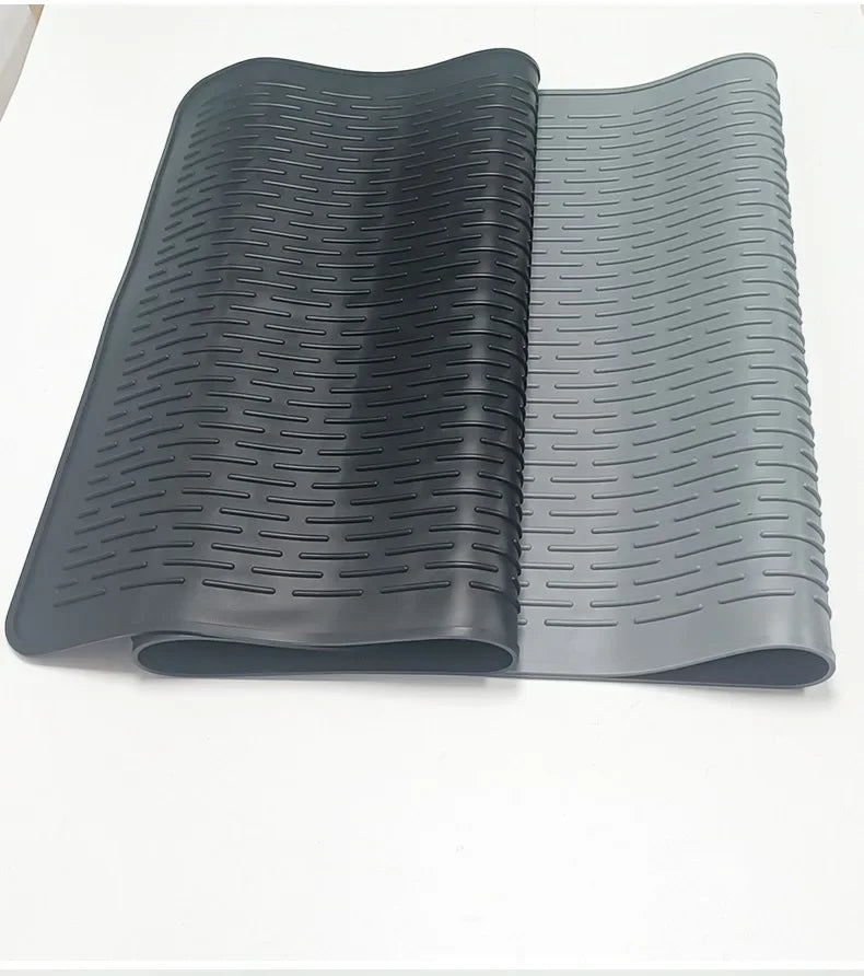 A dark gray silicone induction cooker protector mat rolled up, showing its ribbed texture.