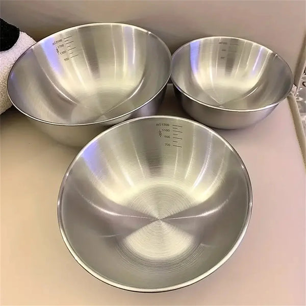 Ein Set aus drei Edelstahl-Rührschüsseln mit Messskalen auf einer hellen Oberfläche.