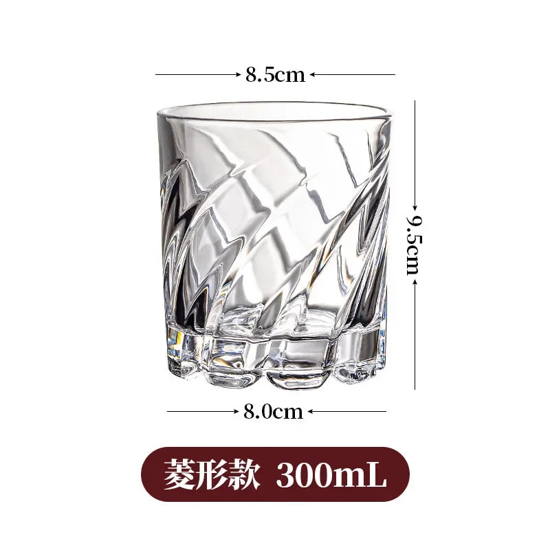 Vaso de whisky claro facetado y giratorio con copa ancha y tallo corto.