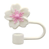 A white flower straw cap with pink stamens and a curved handle.