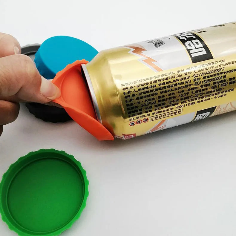 Una mano abre una lata o botella amarilla con tapa de silicona naranja, junto a una tapa de silicona verde.
