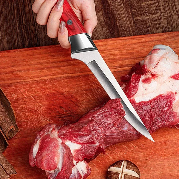 Eine Hand hält ein professionelles Edelstahl-Steckmesser über rohes Fleisch auf einem Holzbrett.