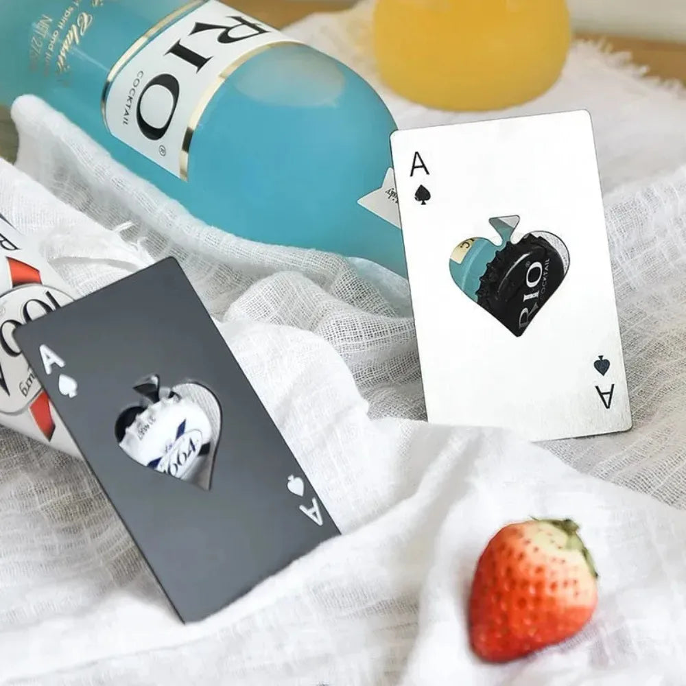 A stainless steel bottle opener set with a bottle and playing cards placed on a white cloth.