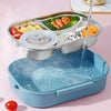 A stainless steel bento lunch box with compartments filled with various foods like eggs, salmon, and rice, shown next to the 
