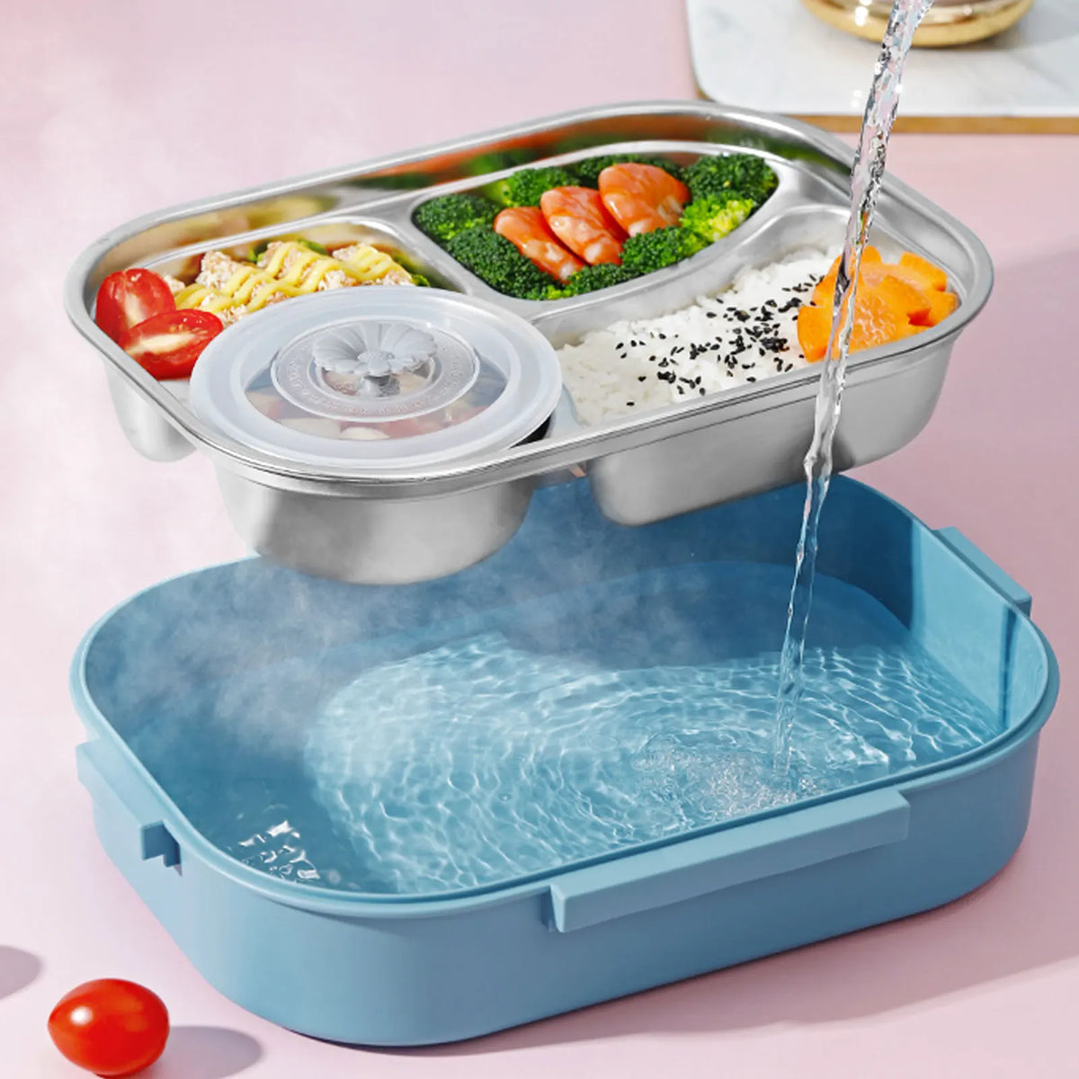 A stainless steel bento lunch box with compartments filled with various foods like eggs, salmon, and rice, shown next to the 