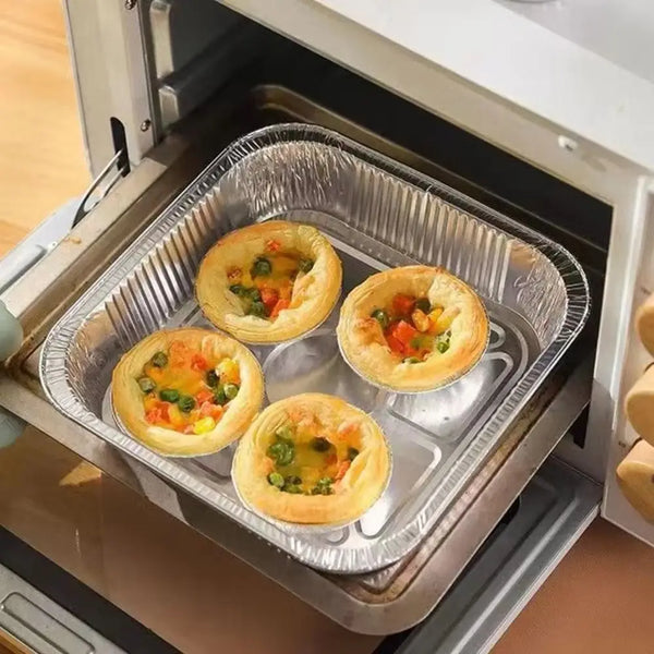 Mehrere goldene herzhafte Eier-Muffins sind in einer Metallbackform im Ofen arrangiert.
