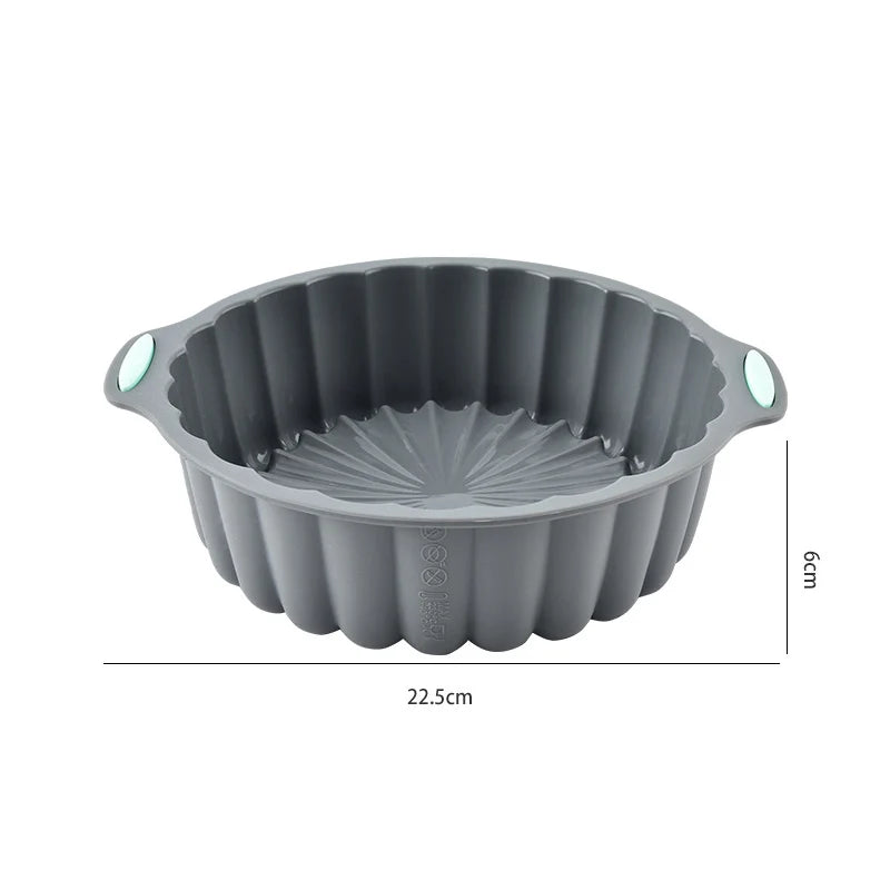A gray silicone baking mold with fluted sides and small handles, shown from above.