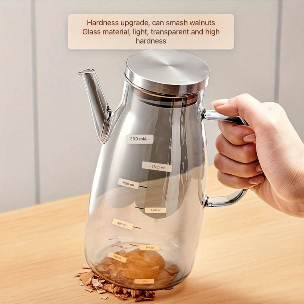 A hand holds a clear glass fuel pump with a silver lid, demonstrating its high hardness and capacity markings.