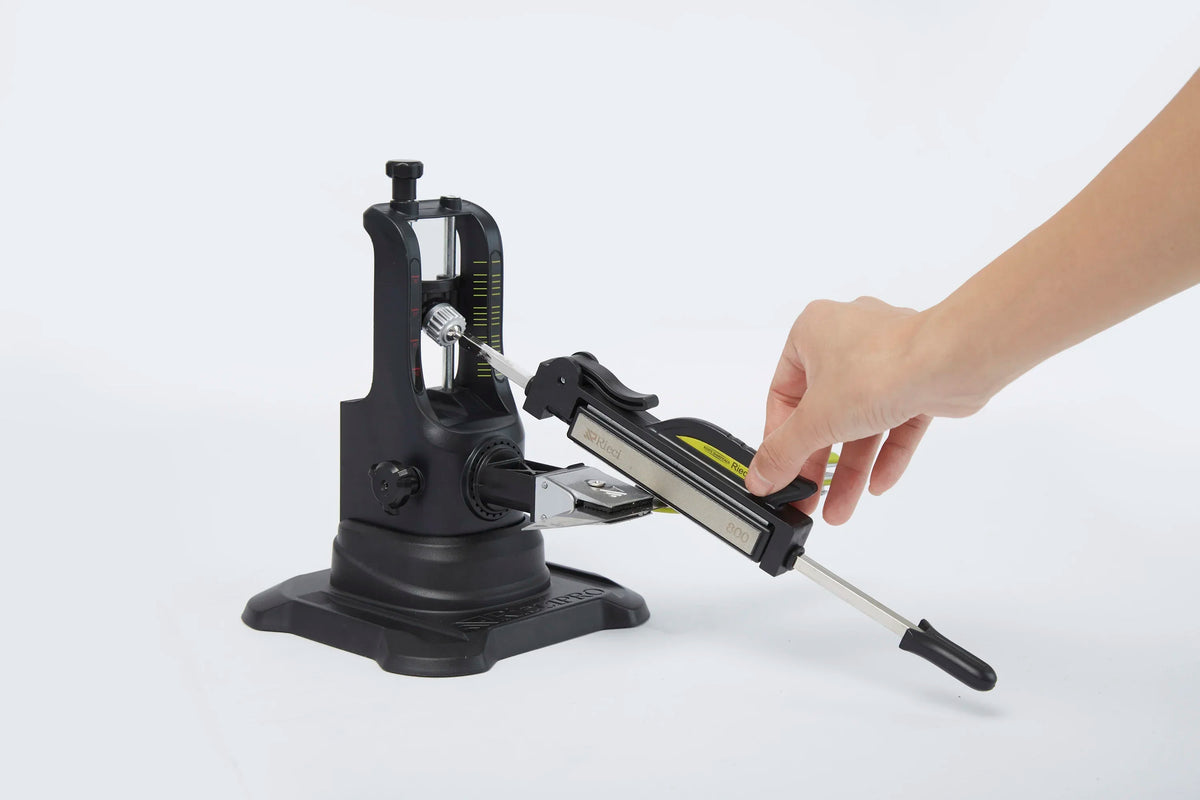 A hand is operating a professional diamond knife sharpener set on a white background.