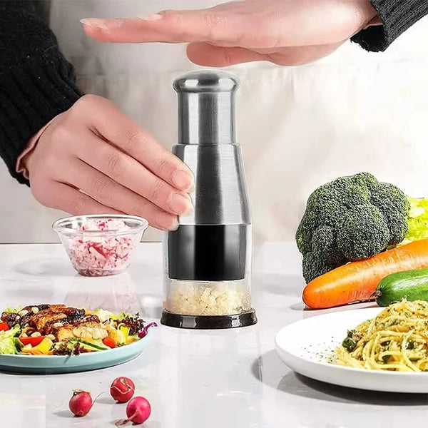 Eine Hand drückt einen manuellen Knoblauch- und Zwiebelpresse-Chopper, mit geschnittenen Zutaten sichtbar.