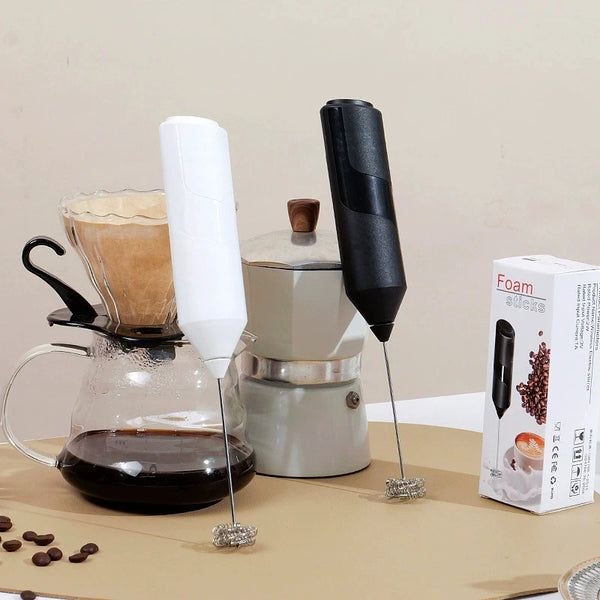 Silber- und schwarzer Handmixer für Milch und Eier mit Glasgefäß und Verpackung.