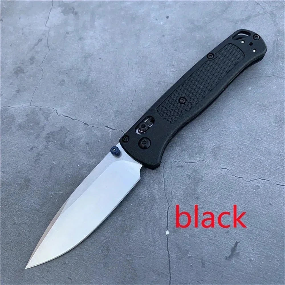 A black folding utility knife with a silver blade resting on a gray surface.