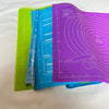 A stack of colorful reusable silicone rolling mats for baking and food preparation