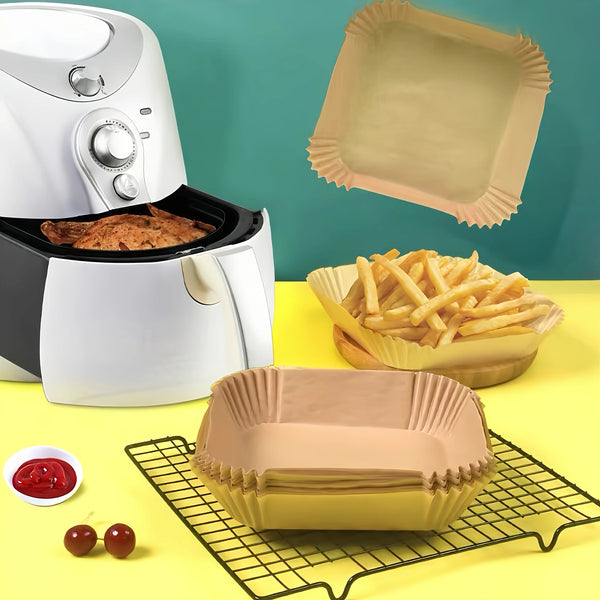 Weiiger Airfryer mit goldener Papierform und gelbem Tablett voller Pommes frites