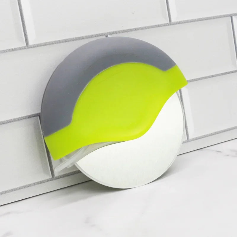 Un set de couteaux à pizza en acier inoxydable avec poignées gris et vert lime, monté sur un fond de carreaux blancs