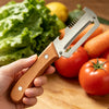 A hand holds an ergonomic wooden vegetable peeler with a stainless steel blade, positioned over fresh vegetables.
