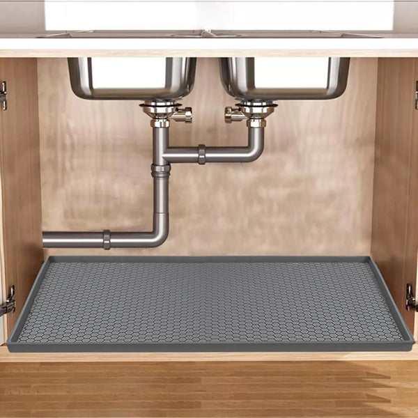 Silikon-Ablaufschale unter der Spüle mit Metallrohr und zwei Schüsseln in einem Schrank