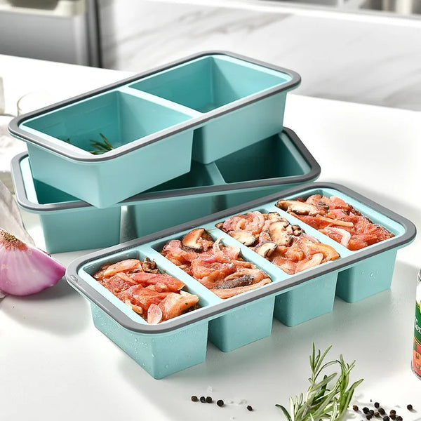Ein Set aus tealfarbenen Silikon-Lebensmittelt감을 mit Deckeln, einige enthalten geschnittenes Fleisch und Kräuter.