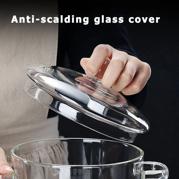 Eine Hand hält eine anti-scalding Glasabdeckung über einen transparenten Glasschmortopf.