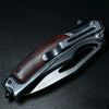 A folding knife with a dark wood handle and a silver steel blade is shown against a black background.