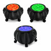 Three black cauldron ornaments filled with brightly colored liquid or substance: orange, green, and blue.