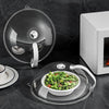 A clear glass splash guard lid is shown resting on a black marble surface next to a white microwave oven.