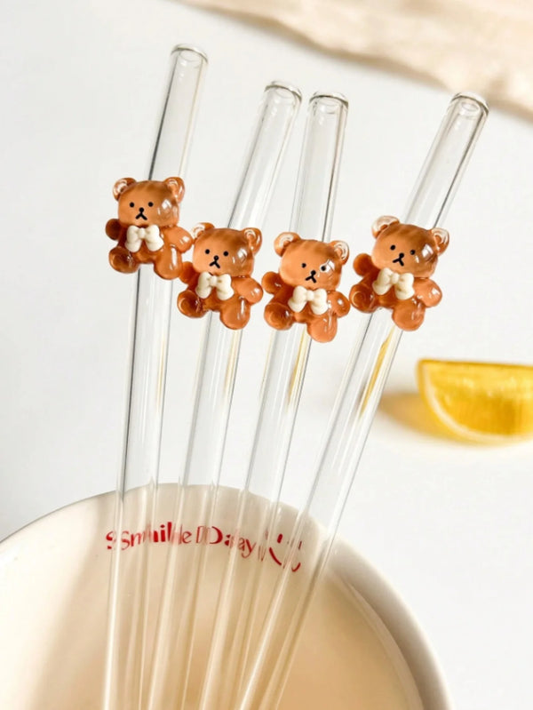 Ein Set wiederverwendbarer Glasstrohhalme mit kleinen Bären-Silikon- oder Plastik-Anhängern.