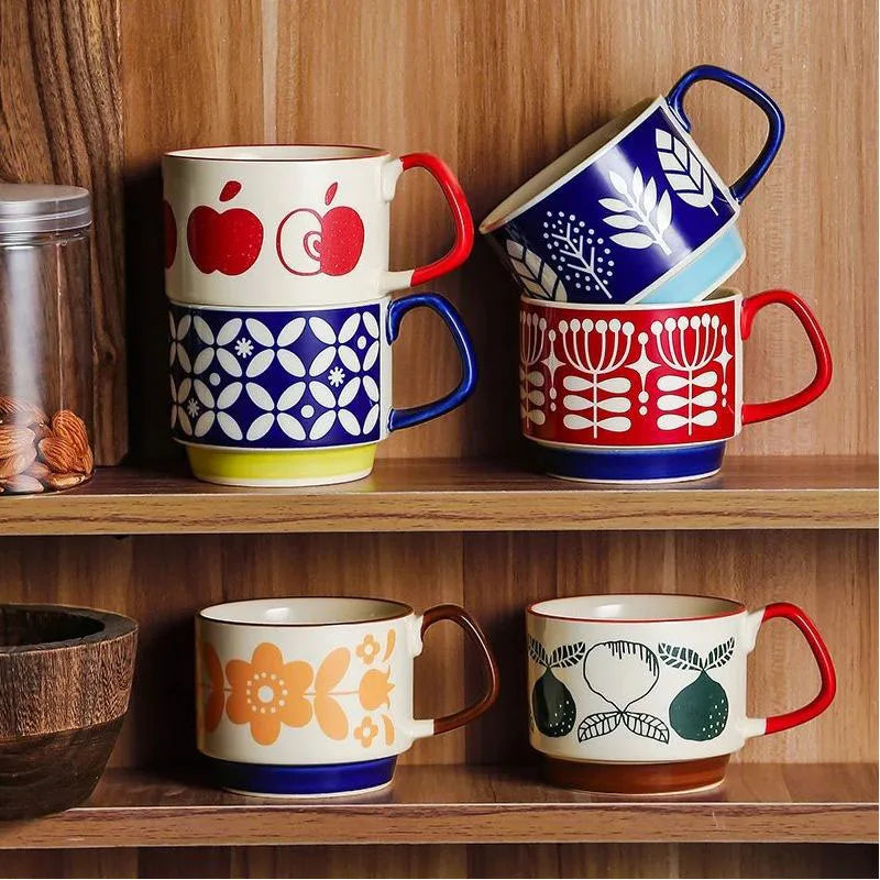 Un ensemble de tasses à café en céramique japonaises rétro bleues, rouges et blanches sur une étagère en bois.