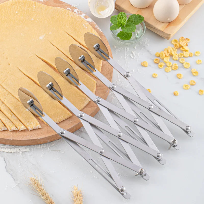 A set of silver multi-function dough cutters with pointed tips resting on a wooden board next to eggs and herbs.