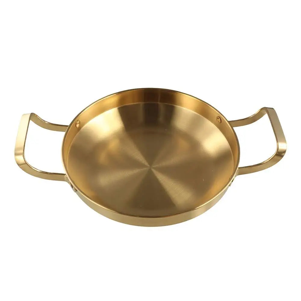 A round, shallow, gold-toned stainless steel BBQ and frying pan with handles.