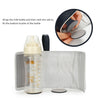 A clear baby bottle with a silicone sleeve and a black silicone fitting is shown next to a silver pouch.