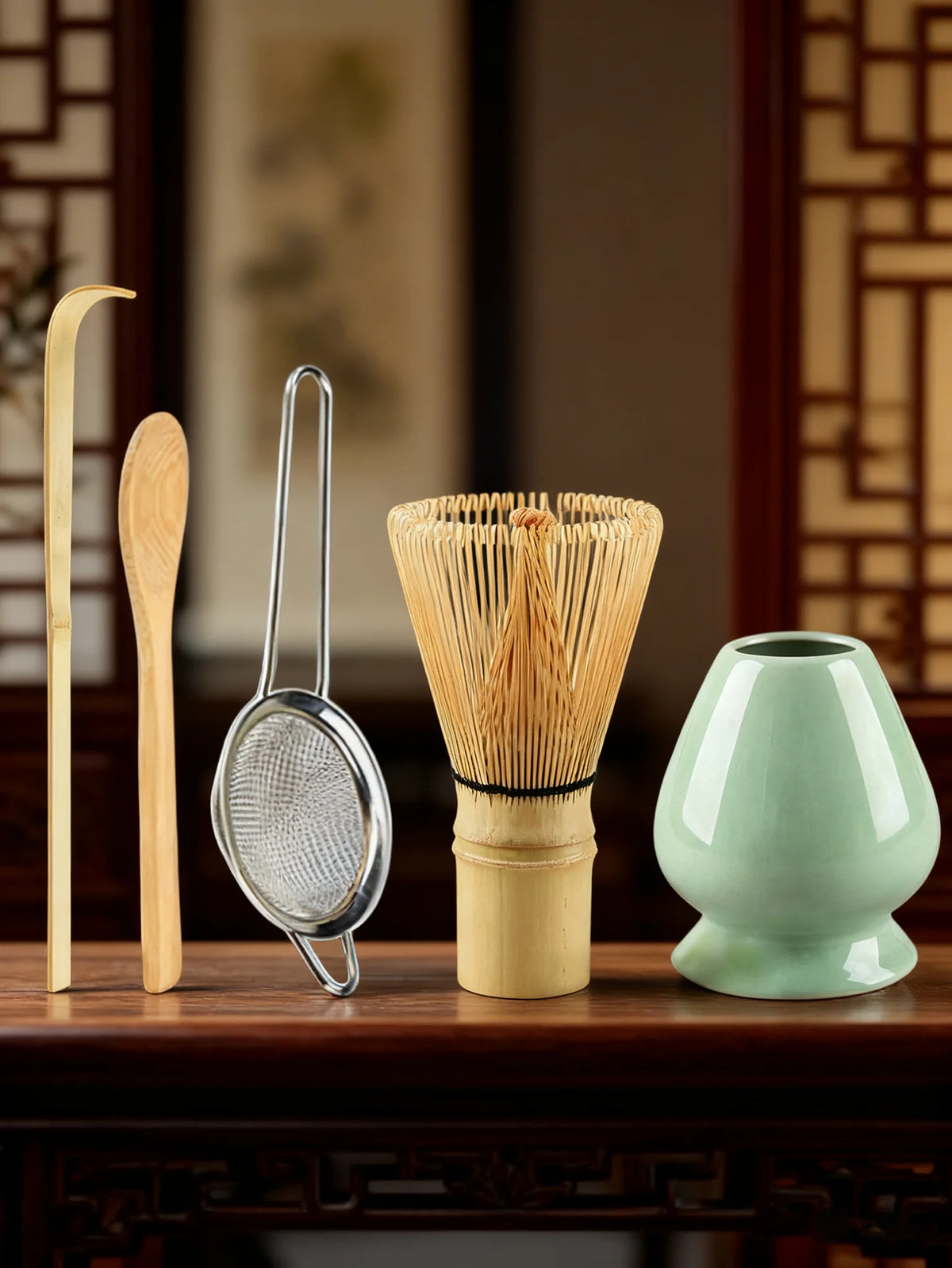 A set of bamboo and metal tools including a whisk, spoon, and a bundle of bamboo straws for tea preparation.