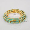 Gold and turquoise acrylic elastic bracelets stacked on a white background.