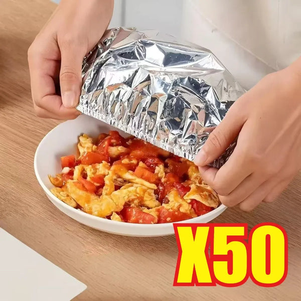 Hände öffnen einen silbernen Aluminiumfolien-Schalendeckel und enthüllen das Essen darin.
