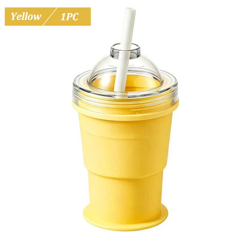 A yellow reusable silicone ice ball cup with a clear lid and a white straw.