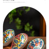 A set of colorful bohemian ceramic ladles resting on a wooden surface.