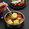 A stainless steel soup ladle is scooping corn and vegetables from a bowl of soup.