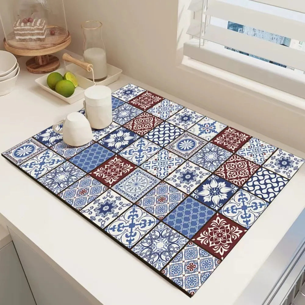 A rectangular absorbent dish drying mat with a blue and white geometric pattern is displayed on a white countertop.