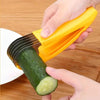 A hand is using a yellow manual vegetable slicer to cut a cucumber on a white plate.