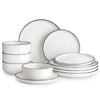 A white ceramic dinnerware set featuring plates and bowls stacked and displayed on a white background.