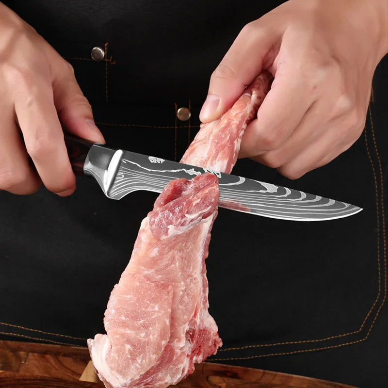 Hands are slicing a piece of raw meat with a Damascus chef knife on a dark cutting board.