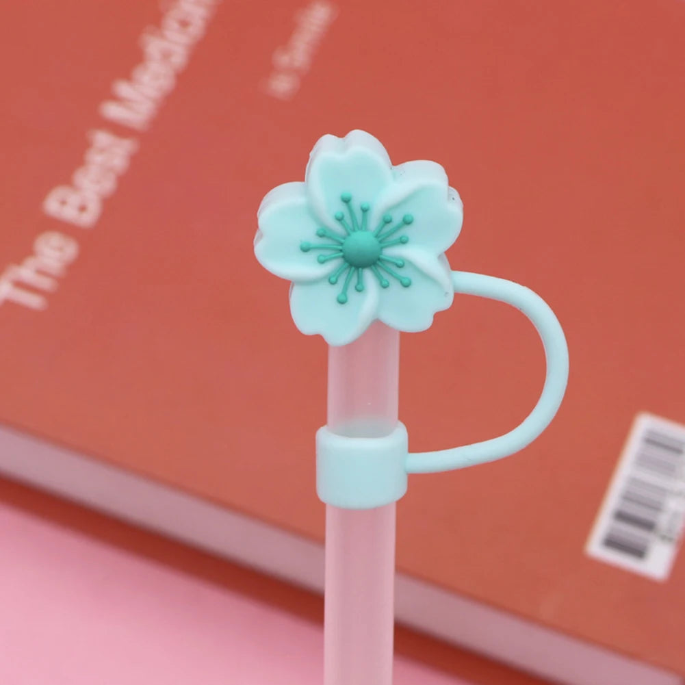A light mint green flower straw cap attached to a pink tumbler straw.