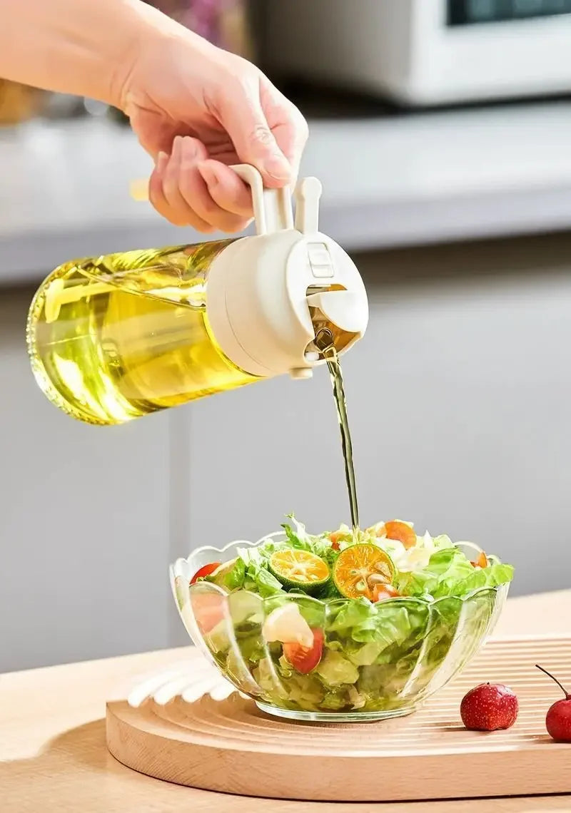 Eine Hand gießt Olivenöl aus einer Glasflasche über einen Salat in einer Schüssel.