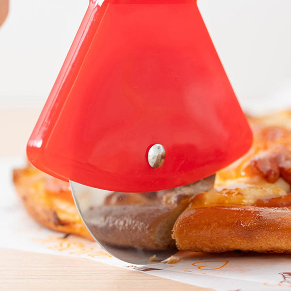 Rotes, axtförmiges Pizzaschneider schneidet eine Pizza auf einer weißen Oberfläche.